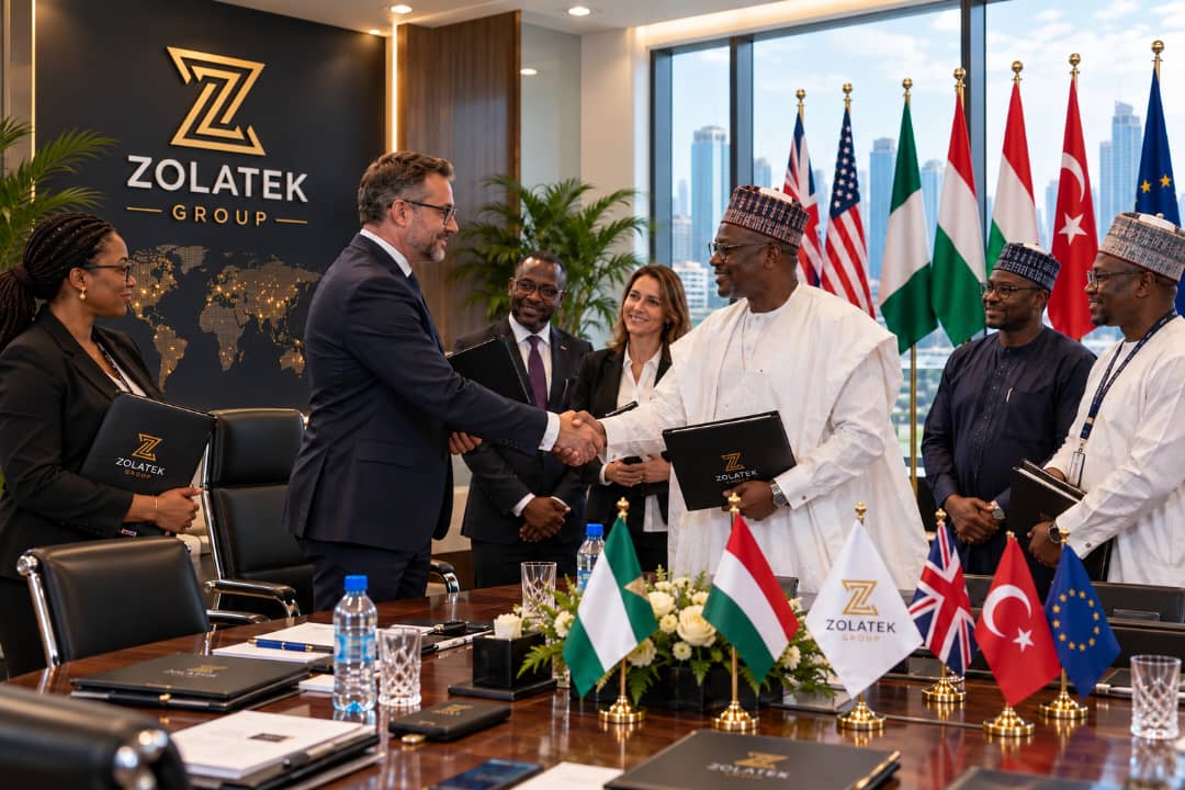 International delegation meeting with Nigerian officials beside multiple national flags